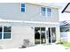Back exterior of home with glass sliding doors, patio, and string lights at 184 Lake Smart Cir, Winter Haven, FL 33881