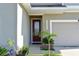 Inviting front entrance with a decorative glass door and manicured landscaping, next to attached garage at 184 Lake Smart Cir, Winter Haven, FL 33881