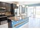 Open kitchen featuring dark wood cabinets, granite countertops, and stainless steel appliances, leading to sliding glass doors at 184 Lake Smart Cir, Winter Haven, FL 33881