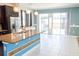 Open kitchen featuring dark wood cabinets, granite countertops, and stainless steel appliances, leading to sliding glass doors at 184 Lake Smart Cir, Winter Haven, FL 33881