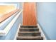 Carpeted staircase leading upstairs, framed by a stylish wood accent wall and blue paint at 184 Lake Smart Cir, Winter Haven, FL 33881