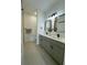 Modern bathroom featuring double vanity, sleek mirrors, and neutral-toned tile flooring at 4295 Nw 1St Court Rd, Ocala, FL 34475