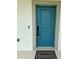 Modern turquoise front door with stylish hardware and welcome mat at 4295 Nw 1St Court Rd, Ocala, FL 34475
