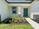 Close up of front door with small flower bed and manicured grass at 4295 Nw 1St Court Rd, Ocala, FL 34475