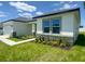 New home features a turquoise front door, stone accents, and manicured landscaping at 4295 Nw 1St Court Rd, Ocala, FL 34475