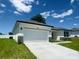 Exterior view featuring a two-car garage with a long driveway and manicured landscaping at 4295 Nw 1St Court Rd, Ocala, FL 34475