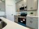 Close up of the kitchen featuring a stainless steel microwave and gray cabinetry at 4295 Nw 1St Court Rd, Ocala, FL 34475