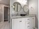Bathroom featuring a double vanity with granite countertop and two round mirrors at 490 Burnt Tree Ln, Apopka, FL 32712