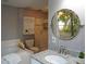 Bathroom featuring a vanity, round mirror, bathtub, and stand-up shower at 490 Burnt Tree Ln, Apopka, FL 32712