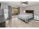 Spacious bedroom with hardwood floors, ceiling fan and sliding glass door to lanai at 490 Burnt Tree Ln, Apopka, FL 32712