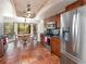Bright kitchen featuring stainless steel appliances, wood cabinets, and terra-cotta flooring at 490 Burnt Tree Ln, Apopka, FL 32712