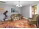 Cozy living room with terra-cotta floors, a comfortable couch, and a large window that lets in natural light at 490 Burnt Tree Ln, Apopka, FL 32712