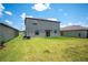 Backyard with a well-maintained lawn and view of the home's sliding glass door entrance at 5553 Turkey Creek Way, Lakeland, FL 33811