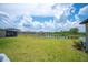 Expansive backyard with lush green grass, a pond, and neighboring houses in a neighborhood at 5553 Turkey Creek Way, Lakeland, FL 33811