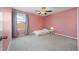 Bedroom with a gray carpet, pink walls, and a window with sheer gray curtains at 5553 Turkey Creek Way, Lakeland, FL 33811