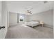 Bright bedroom features neutral walls, carpet, ceiling fan, and a sun-filled window at 5553 Turkey Creek Way, Lakeland, FL 33811
