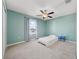 Bright bedroom with light blue walls, carpet floor, ceiling fan, and a window with curtains at 5553 Turkey Creek Way, Lakeland, FL 33811