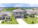 A two-story home featuring blue shutters, a well-manicured lawn, and community pond at 5553 Turkey Creek Way, Lakeland, FL 33811