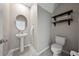 Cozy half-bathroom featuring a modern pedestal sink and shelving for added storage at 5553 Turkey Creek Way, Lakeland, FL 33811
