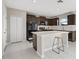 Modern kitchen with dark cabinets, white countertops, and an island with bar stool seating at 5553 Turkey Creek Way, Lakeland, FL 33811