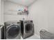 Laundry room featuring modern washer and dryer units with overhead shelving for storage at 5553 Turkey Creek Way, Lakeland, FL 33811