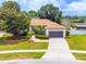 Charming single-story home featuring a two-car garage, lush landscaping, and a well-manicured lawn on a sunny day at 8023 Canyon Lake Cir, Orlando, FL 32835