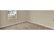 A carpeted room with neutral walls has a window providing a view of cars in a neighborhood at 1068 Clay Blvd, Tavares, FL 32778