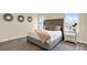 Inviting bedroom featuring a stylish upholstered bed, modern nightstands, and natural light from the windows at 1076 Clay Blvd, Tavares, FL 32778
