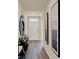 Inviting entryway featuring wood-look floors, a decorative mirror and artwork creating a modern aesthetic at 1076 Clay Blvd, Tavares, FL 32778