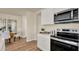 Open kitchen features stainless steel appliances, white cabinets, and opens to a dining area with wood floors at 1076 Clay Blvd, Tavares, FL 32778