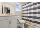 A bright bathroom features a patterned shower curtain, a white vanity, and a large window at 1103 Silo Dr, St Cloud, FL 34771