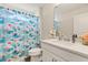 This bathroom features a bright shower curtain and a white vanity at 1103 Silo Dr, St Cloud, FL 34771