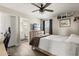 Cozy bedroom with wood floors, ceiling fan, a TV, and an en-suite bathroom at 1103 Silo Dr, St Cloud, FL 34771