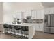 Kitchen island with white cabinets, stone countertop, stainless appliances, and breakfast bar at 1103 Silo Dr, St Cloud, FL 34771