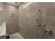 This tiled walk-in shower offers a pebble floor, adjustable shower head, and modern fixtures at 1103 Silo Dr, St Cloud, FL 34771