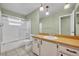 Bathroom with a shower and bathtub combo, along with wood grain vanity and decorative lighting at 1111 Lynx Trl, Winter Springs, FL 32708