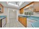 Bright kitchen features wood cabinets, blue countertops, stainless appliances, tile floor, and large skylight at 1111 Lynx Trl, Winter Springs, FL 32708