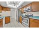 Spacious kitchen features wood cabinets, stainless appliances, tile floor, blue countertops, and large skylight at 1111 Lynx Trl, Winter Springs, FL 32708