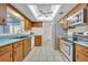 Spacious kitchen features wood cabinets, stainless appliances, tile floor, blue countertops, and large skylight at 1111 Lynx Trl, Winter Springs, FL 32708