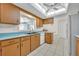Bright kitchen features wood cabinets, blue countertops, stainless appliances, tile floor, and large skylight at 1111 Lynx Trl, Winter Springs, FL 32708