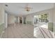 Open living room with sliding door to the back yard, tile floor, neutral paint, and decorative wainscoting at 1111 Lynx Trl, Winter Springs, FL 32708