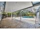 Back patio with brick flooring and a screened-in pool and lounging area at 1111 Lynx Trl, Winter Springs, FL 32708