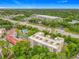Aerial view of a multi-story condo building with community pool, tennis court, and shopping in the background at 1150 Carmel Cir # 301, Casselberry, FL 32707