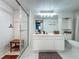 All-white bathroom featuring a glass shower enclosure, wood bench, and a modern vanity with ample storage at 1150 Carmel Cir # 301, Casselberry, FL 32707