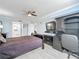 Bedroom featuring a ceiling fan, mounted TV, desk, and view of the ensuite bathroom at 1150 Carmel Cir # 301, Casselberry, FL 32707