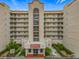 Multi-story condo building featuring balconies, red roof accents, landscaping, and street-facing entry with the address 1150 at 1150 Carmel Cir # 301, Casselberry, FL 32707