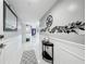 Bright hallway with a white wainscoting and a decorative mirror and floral wall art at 1150 Carmel Cir # 301, Casselberry, FL 32707