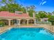 Poolside view featuring lounge area, clubhouse, and tennis courts in a lush green setting at 1150 Carmel Cir # 301, Casselberry, FL 32707