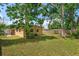 Exterior side view of home, fenced yard, and mature trees at 1219 Helen St, Apopka, FL 32703