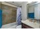 Bathroom with tiled shower and tub, large mirror and modern fixtures at 1219 Helen St, Apopka, FL 32703
